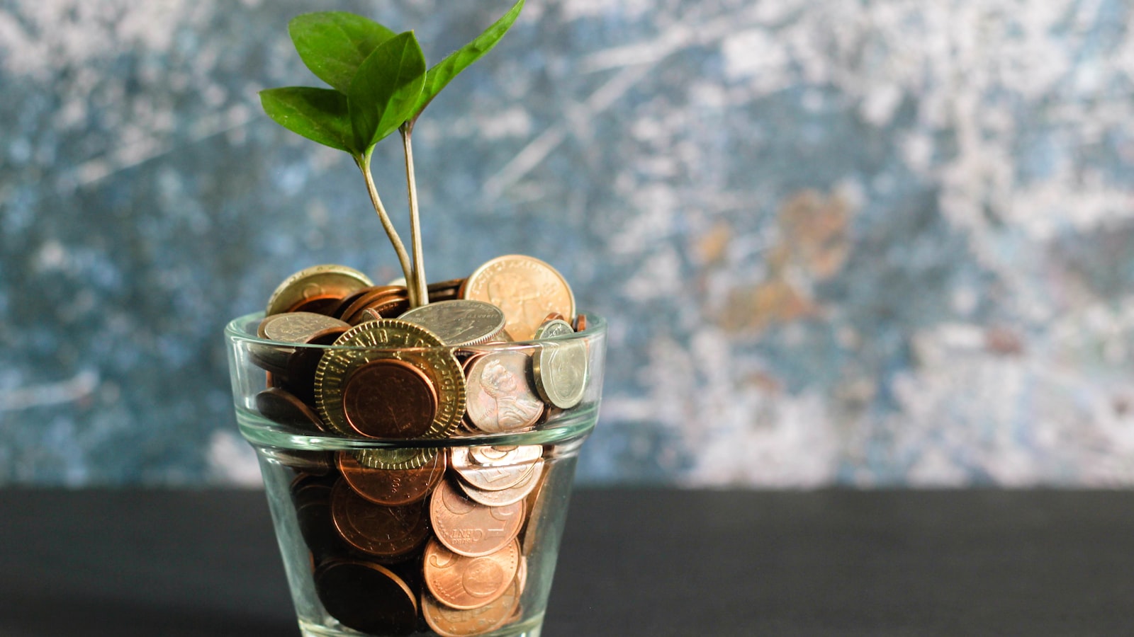Cashback Exchange Là Gì? Cách Nhận Hoàn Phí Cao Nhất Khi Giao Dịch Forex Đồng tiền xu và tờ tiền giấy đặt cạnh nhau trên bàn, minh họa sự khác biệt giữa cashback trả bằng tiền thật và bonus credit trong giao dịch forex